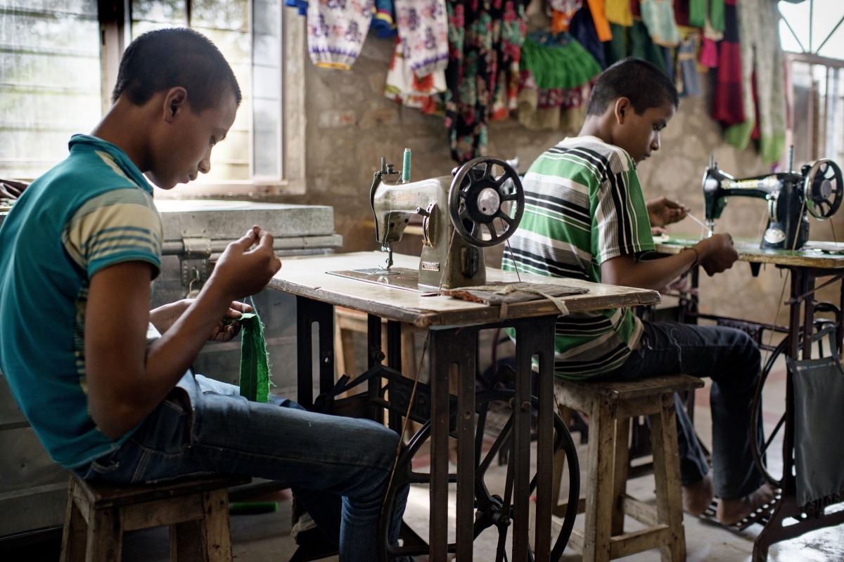 2 poor guys working on sewing machine