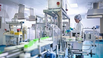 Công nhân đang kiểm tra sản phẩm trên dây chuyền sản xuất trong nhà máy dược phẩm.        4o